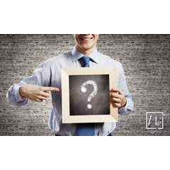 A man in a dress shirt holding a chalkboard with a question mark to represent WarmlyYours radiant heating information.