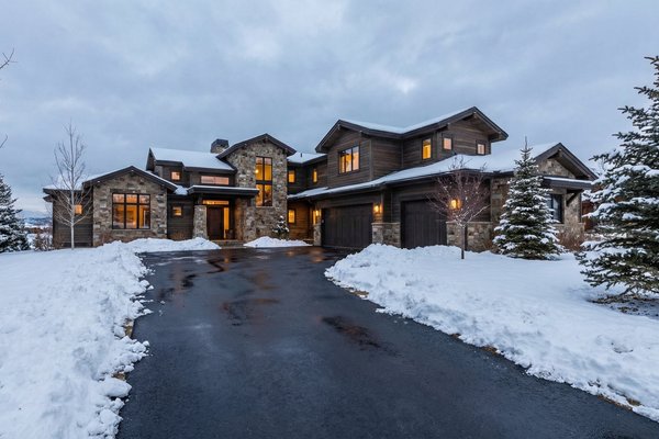 A clear asphalt driveway at a luxury mountain home during winter, kept free of snow by an installed snow melting system.