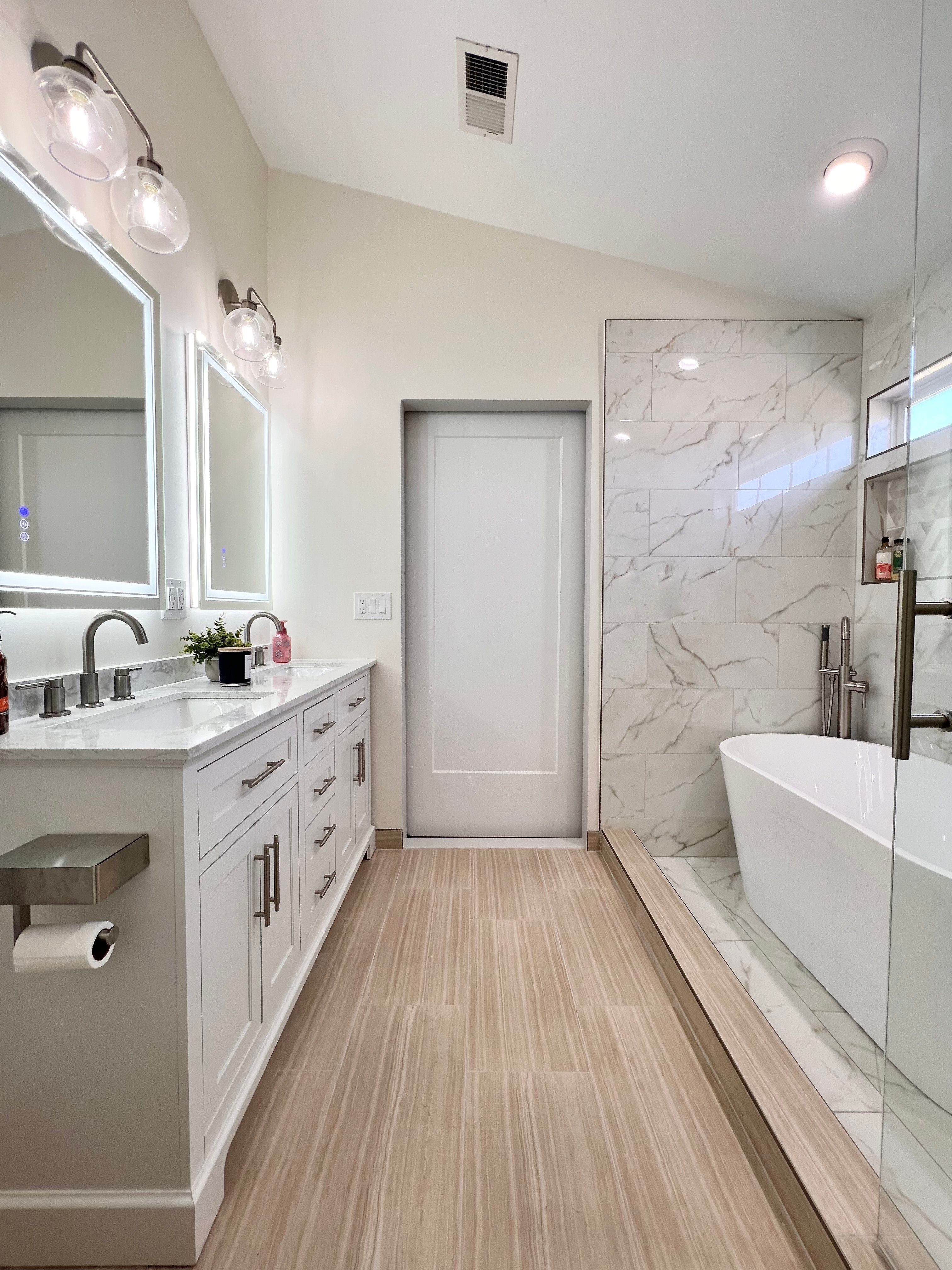 A modern bathroom remodel featuring a wet room with a soaking tub and wood-look tile floors equipped with electric radiant floor heating.