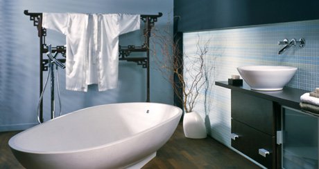 A modern Asian-inspired bathroom featuring a white freestanding bathtub and a dark wood vanity with a vessel sink.