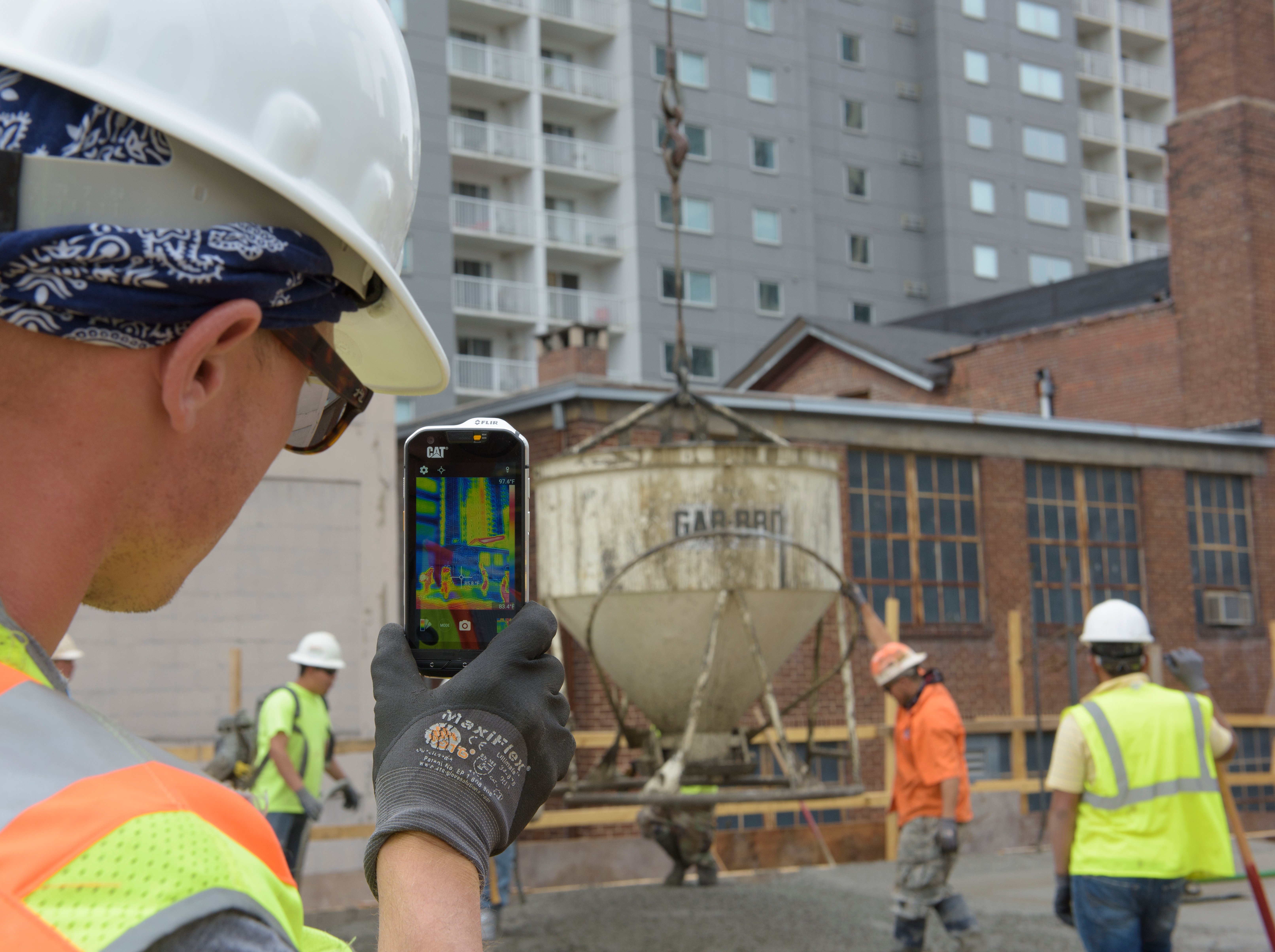 Asphalt crew using Cat S60 smartphone with thermal camera SmartGuide Remote Install Supervision for Floor Heating