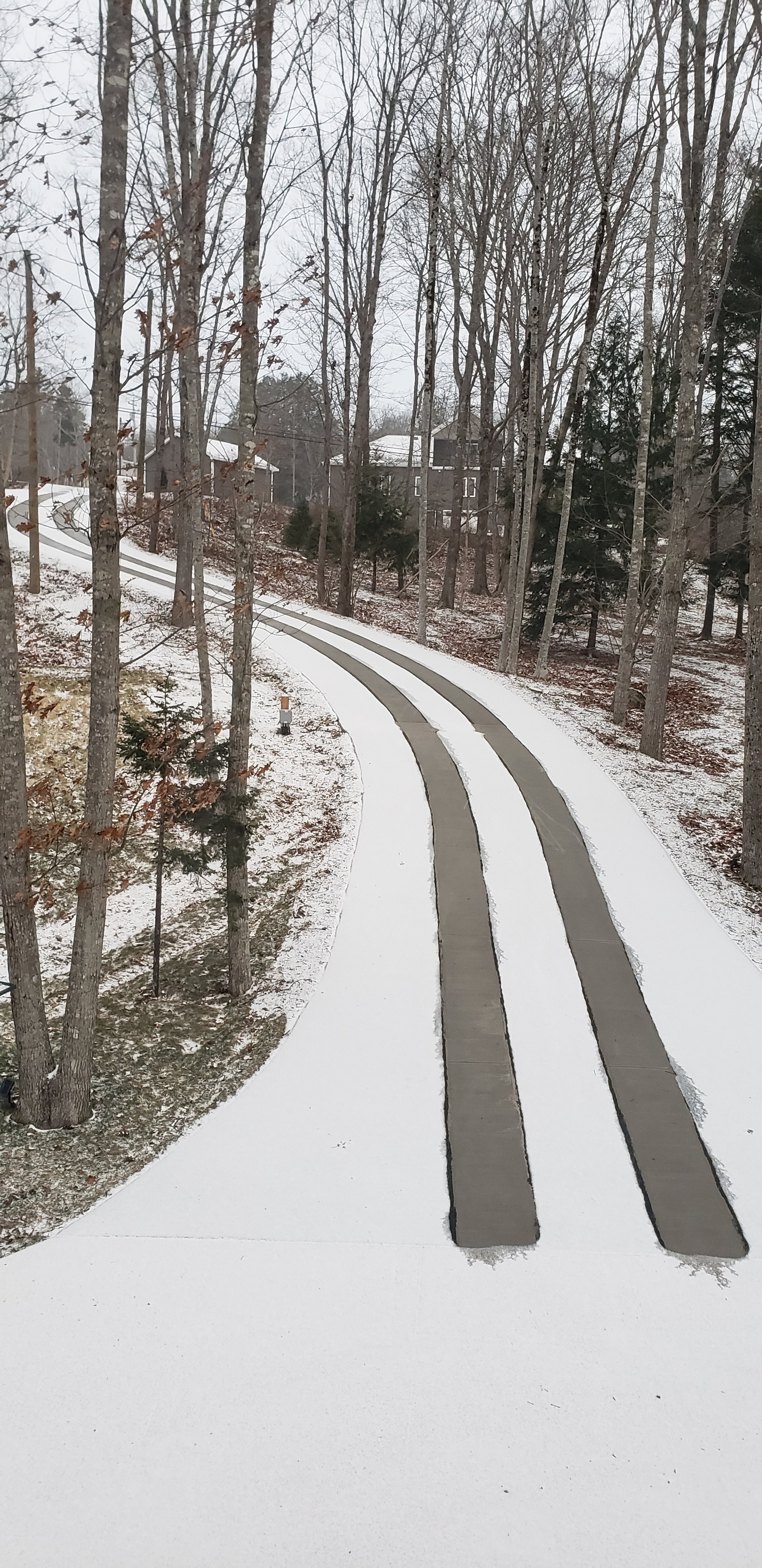 Asphalt driveway retrofit with snow melting tire tracks base of driveway
