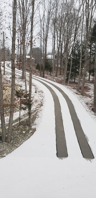 Asphalt driveway retrofit with snow melting tire tracks base of driveway