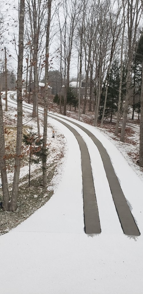 Asphalt driveway retrofit with snow melting tire tracks base of driveway