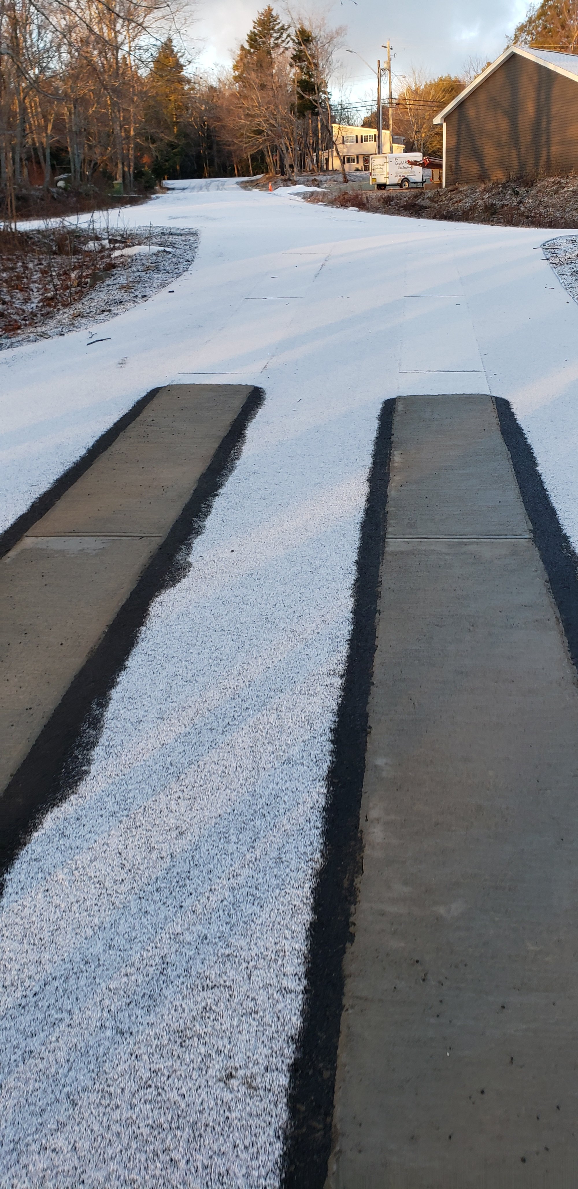 Asphalt driveway retrofit with snow melting tire tracks closeup