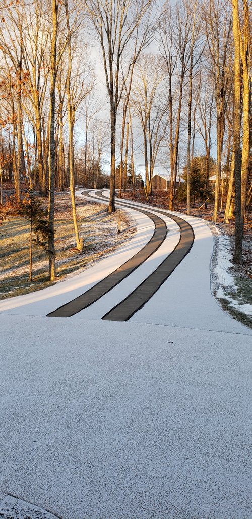 Asphalt driveway retrofit with snow melting tire tracks from road