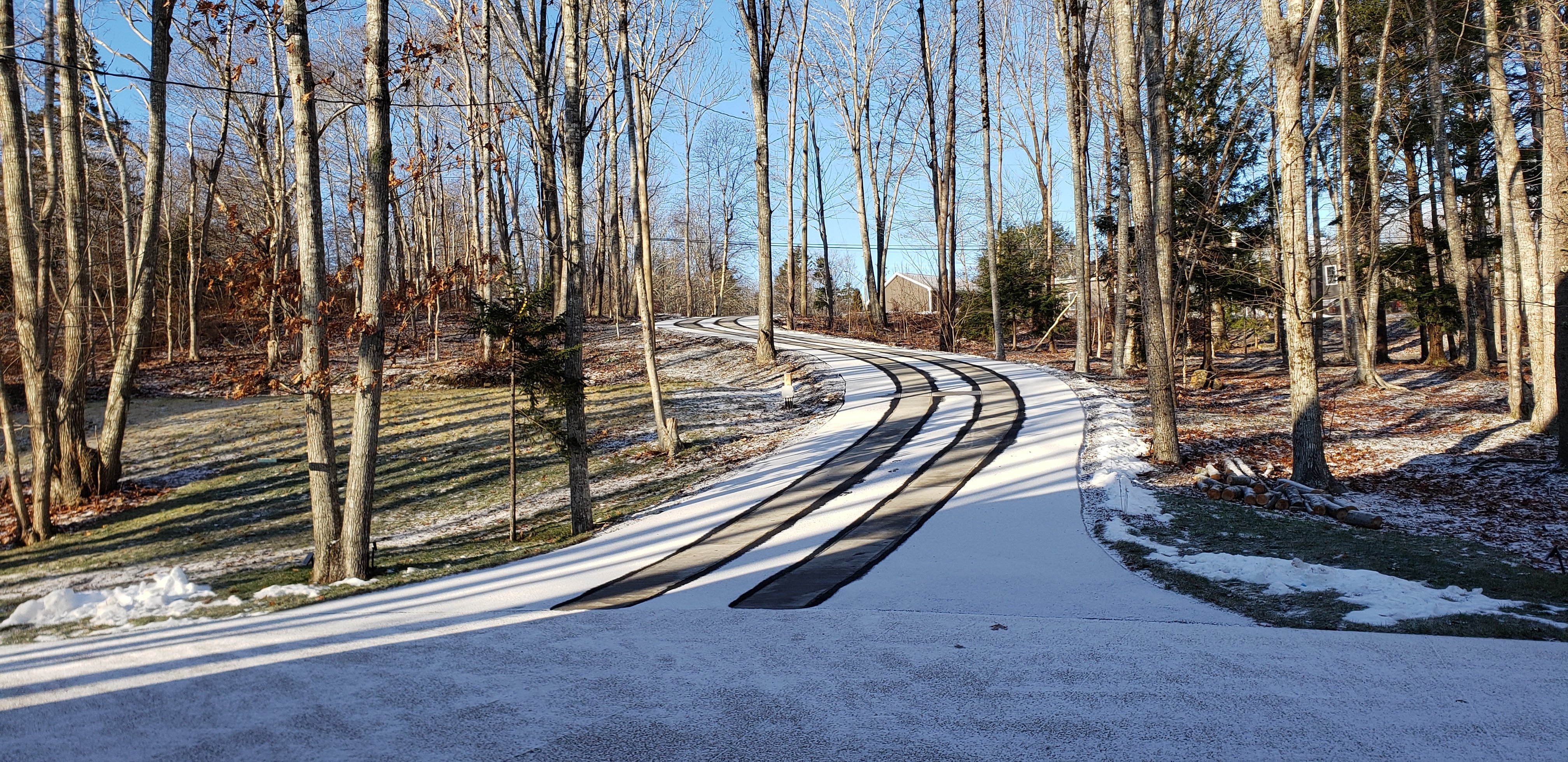 Asphalt driveway retrofit with snow melting tire tracks wide shot