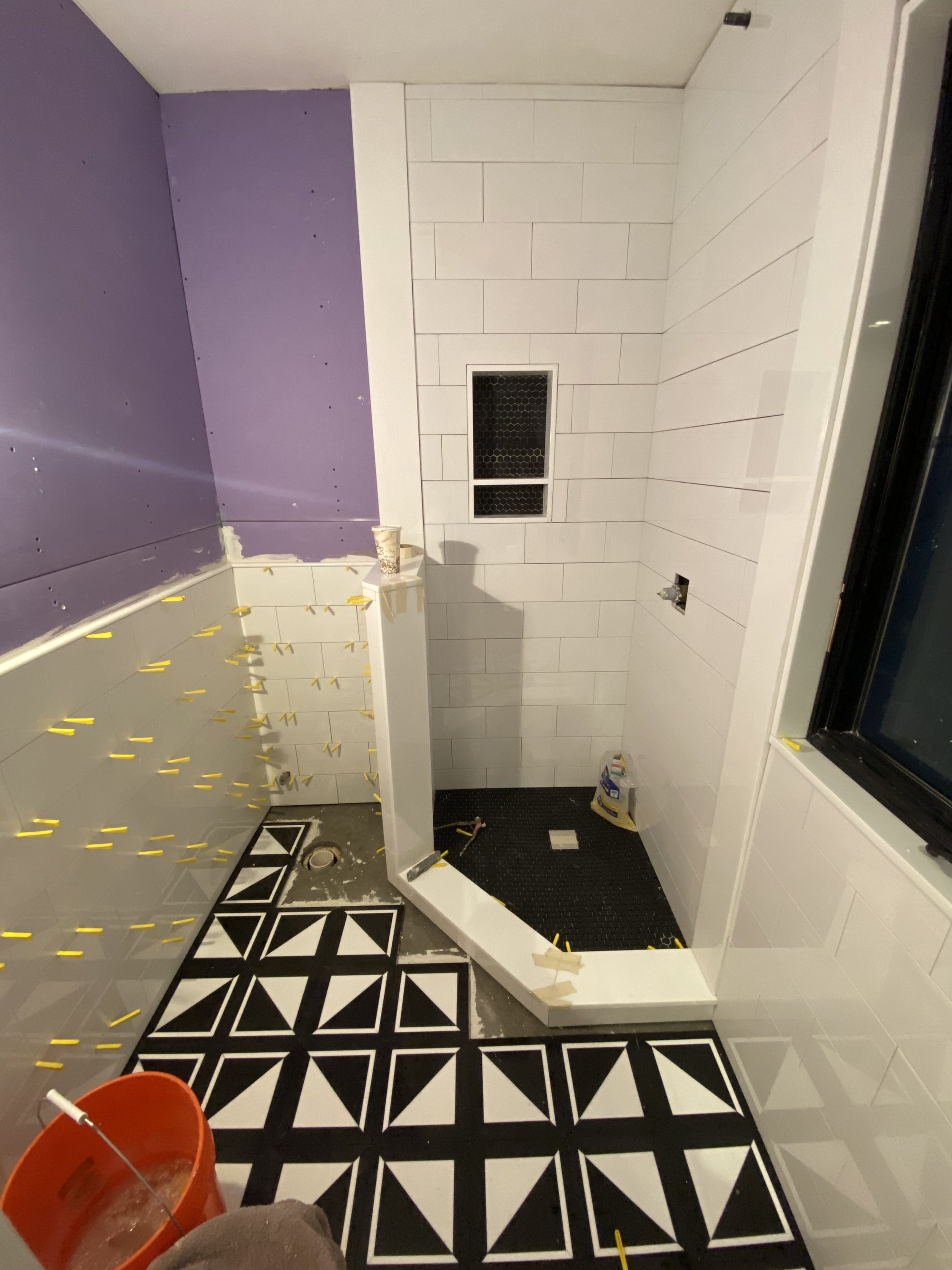 Bathroom with black and white heated tile floor during installation