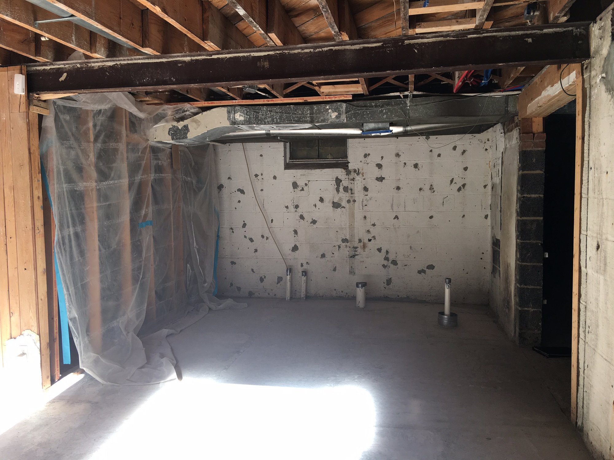 Before shot of wine cellar with kitchen and bar by Architectural Justice