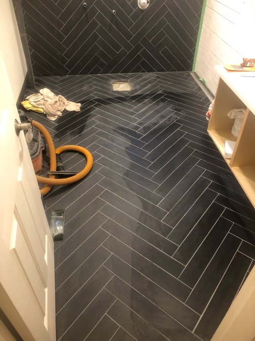 Black tile herringbone floor installed over floor heating system