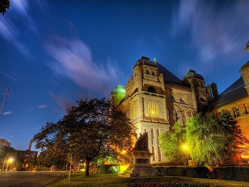 Casa Loma in Toronto, Ontario, featuring a historic Richardsonian Romanesque stone building with towers and arched windows at night.