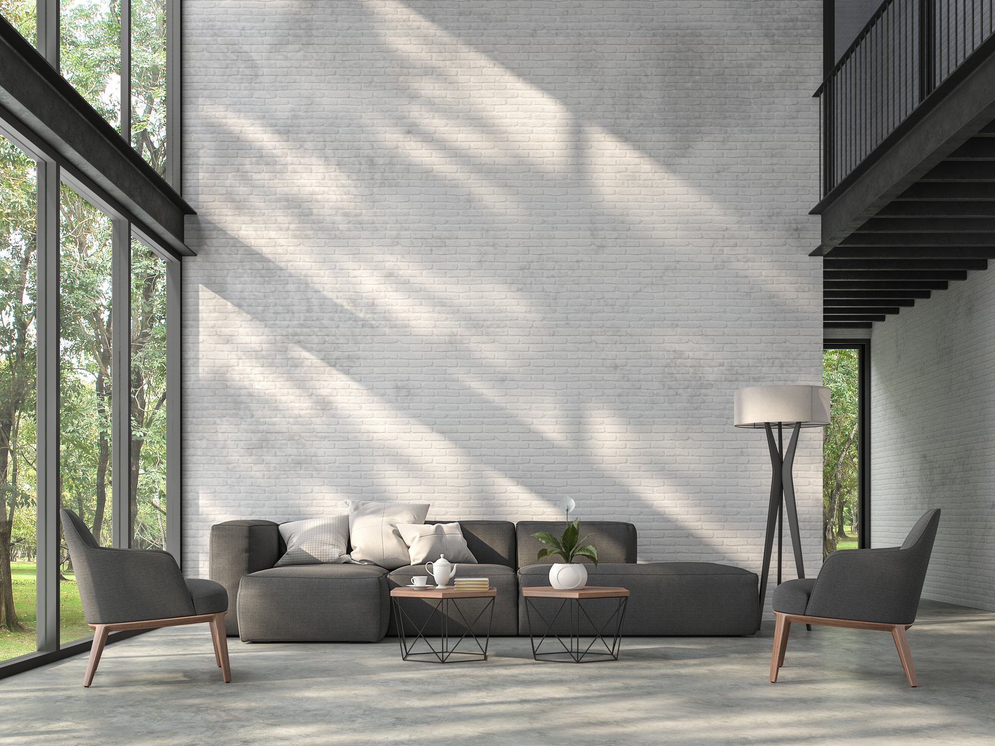 Modern living room with polished concrete flooring and a white brick accent wall featuring a dark grey sectional sofa and industrial windows.