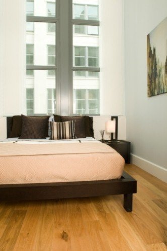 A contemporary bedroom featuring light natural hardwood floors suitable for electric radiant floor heating.