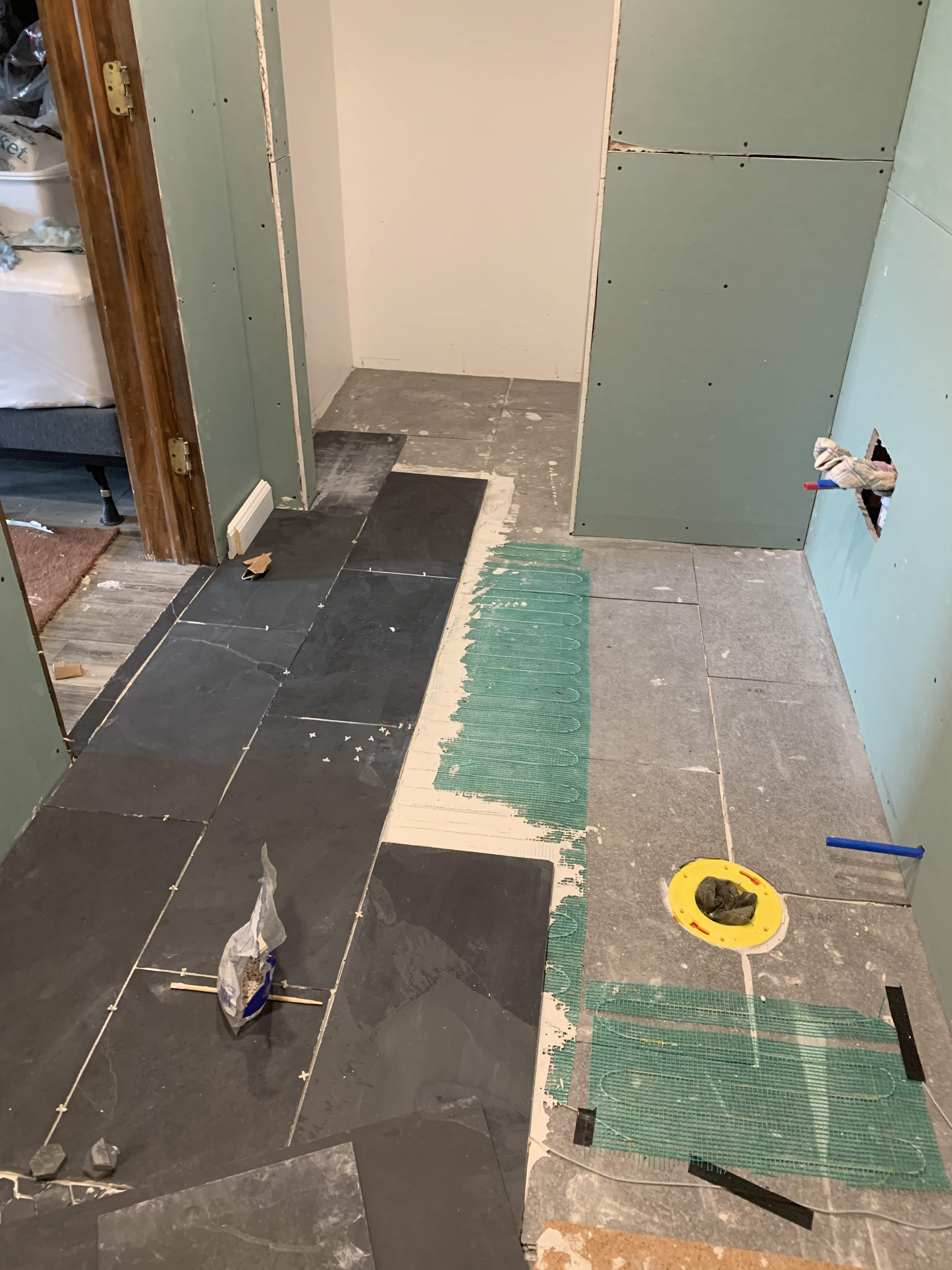 tiles being laid out for a basement bathroom