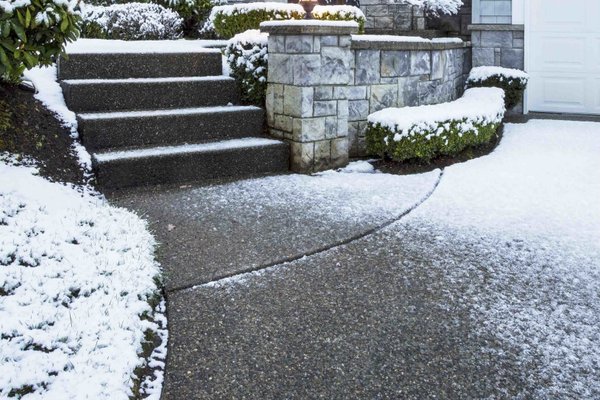 Decorative concrete stairs and driveway with snow