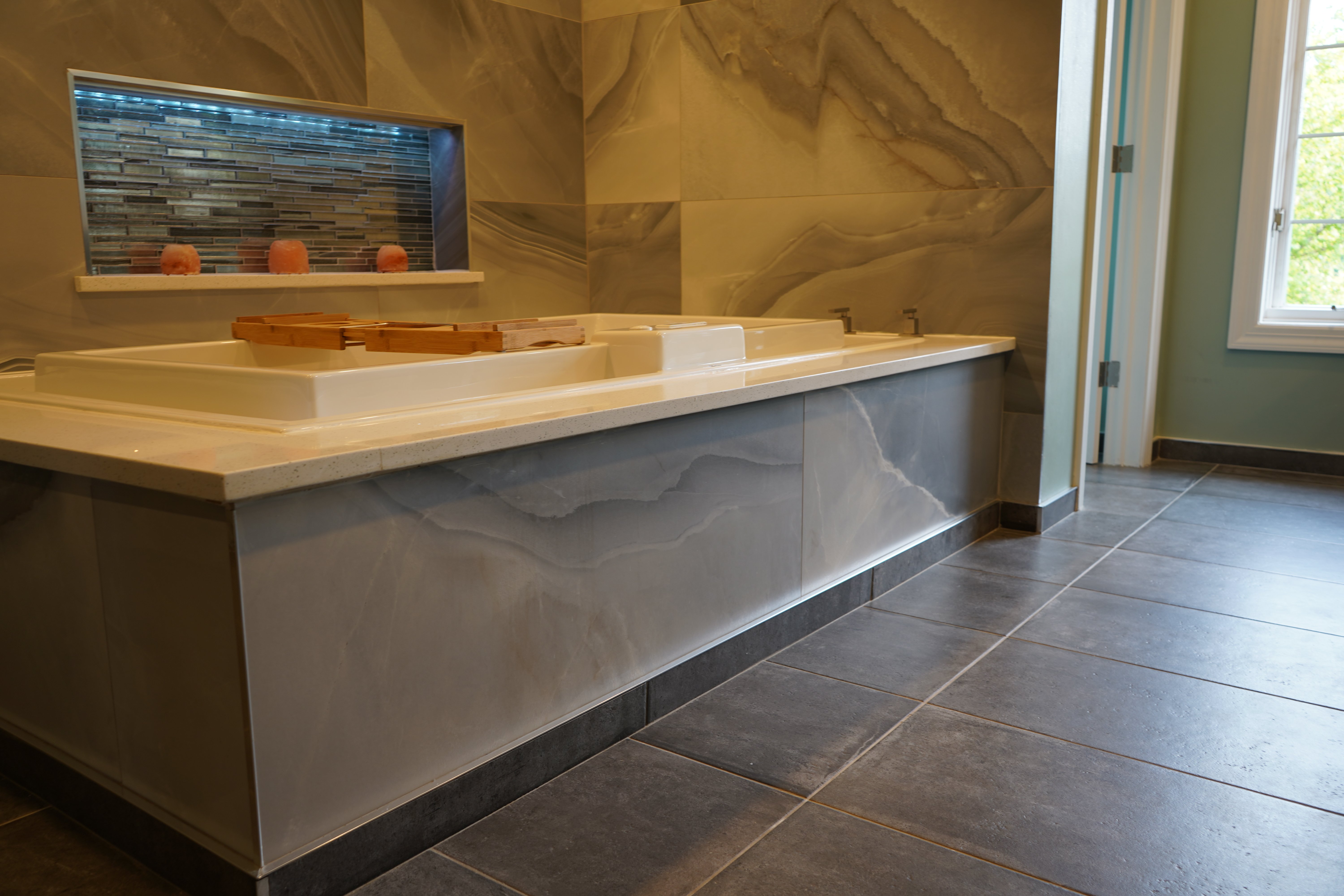 A luxury bathroom featuring TempZone electric radiant floor heating installed beneath dark gray tile flooring.