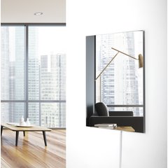 Ember glass mirror infrared heating panel mounted vertically on a modern living room wall.