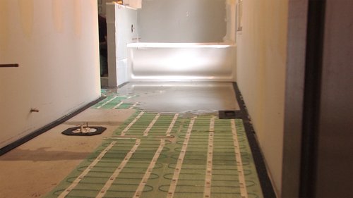 Floor Heating Mat Rolled Out with Self Leveling Cement During Installation