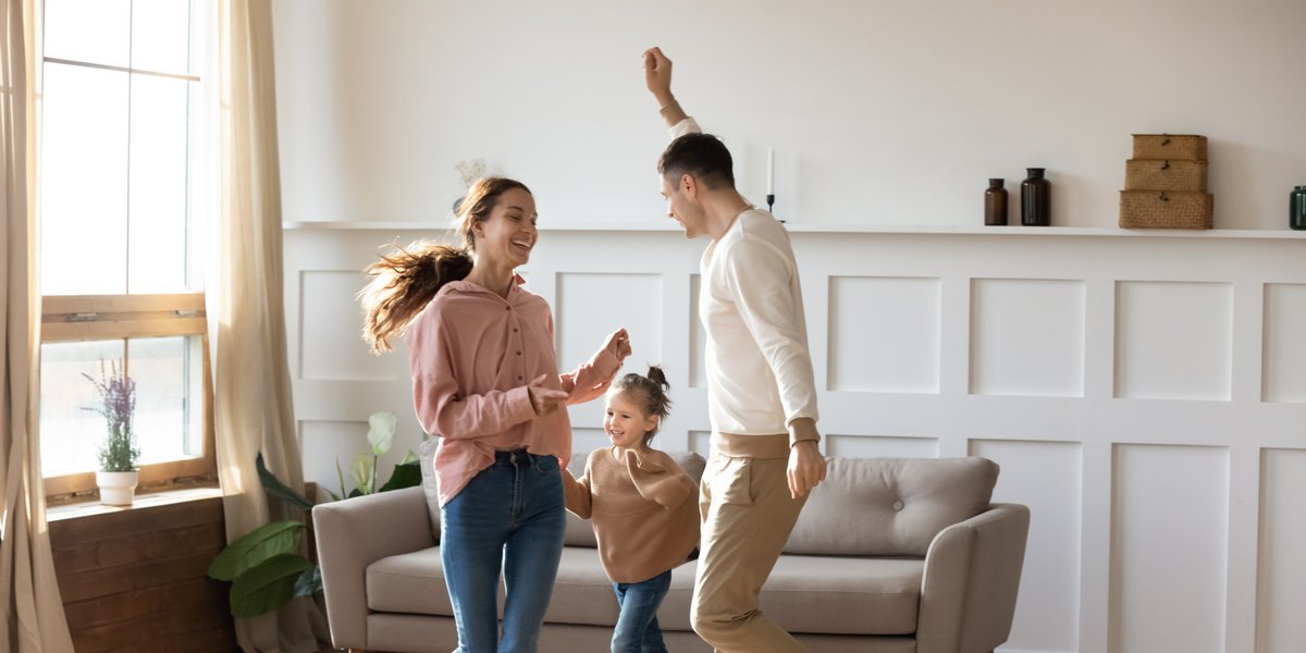 Happy family dancing on floor barefoot