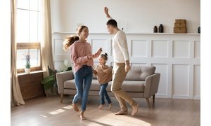 Happy family dancing on floor barefoot