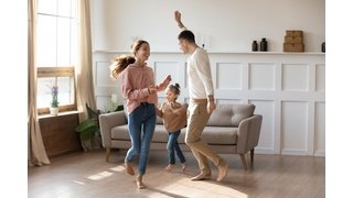 Happy family dancing on floor barefoot