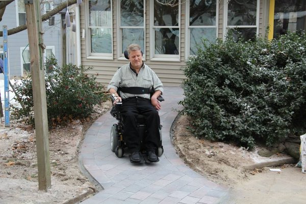 Rob Butts using completed heated wheelchair ramp in Hudson, MA showing successful snow melting system installation