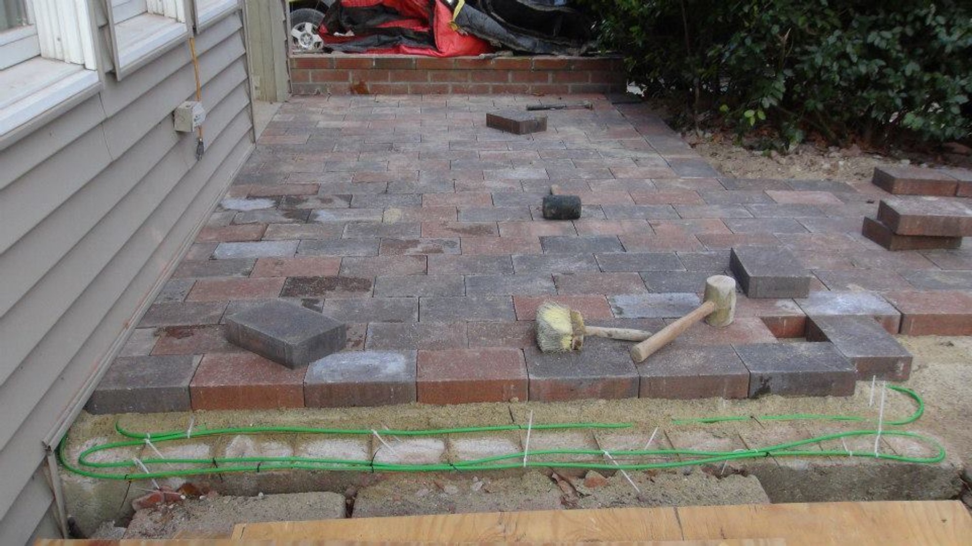 Brick pavers being reinstalled over snow melting cables on heated wheelchair ramp in Hudson, MA