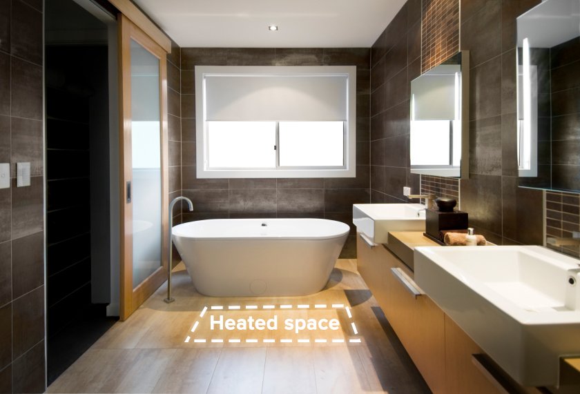 A modern bathroom with a freestanding tub and a highlighted floor area indicating the installation zone for electric radiant floor heating.