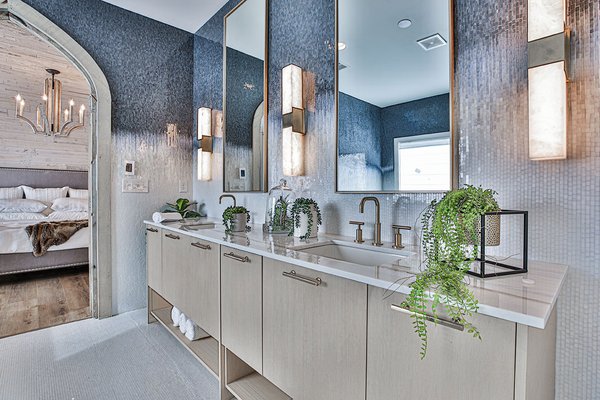 Light wood master bathroom vanity and gold fixtures over a luxury tile floor heating installation.