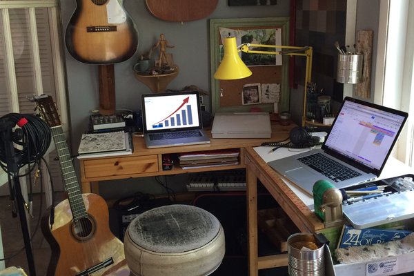 Home office with musical instruments and a chart