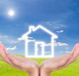 A conceptual illustration of a glowing house outline held in hands, representing energy-efficient radiant floor heating systems.