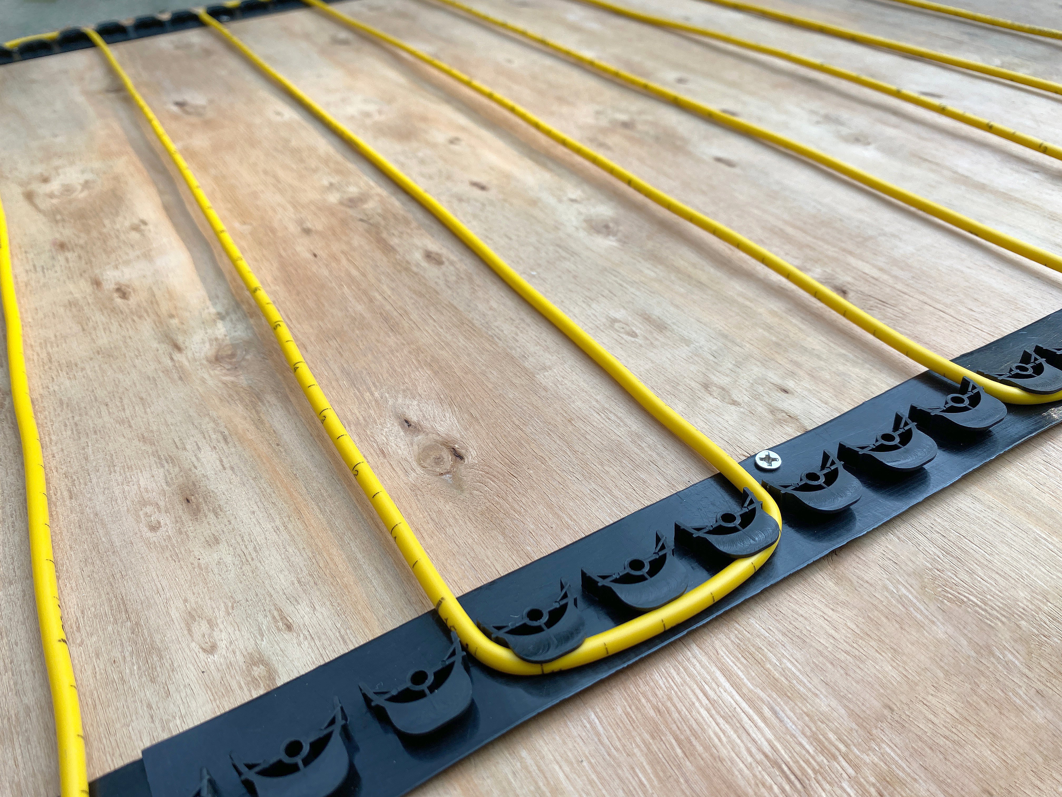 Electric floor heating cables being installed over subfloor