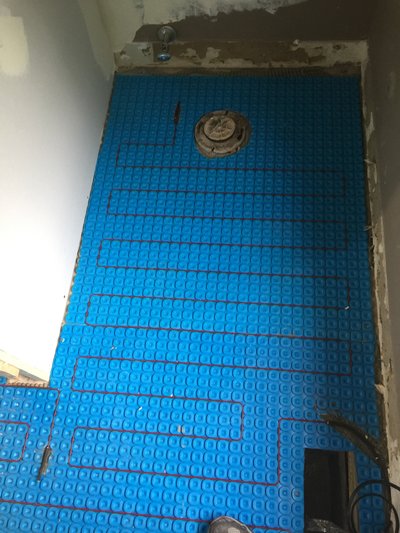 Install shot of Prodeso Uncoupling Membrane with Electric floor heating cable for a bathroom