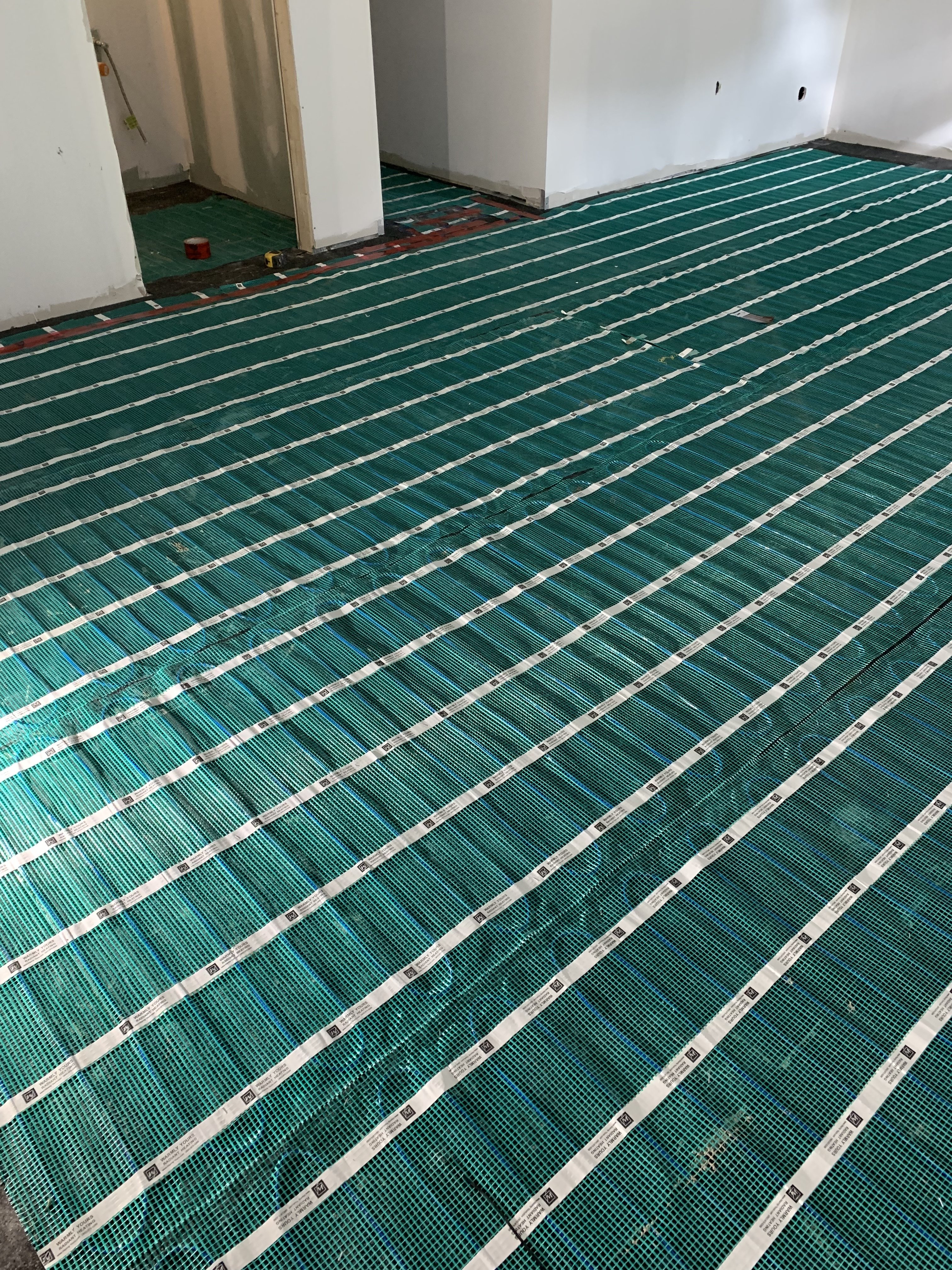Floor heating rolls being installed in a basement