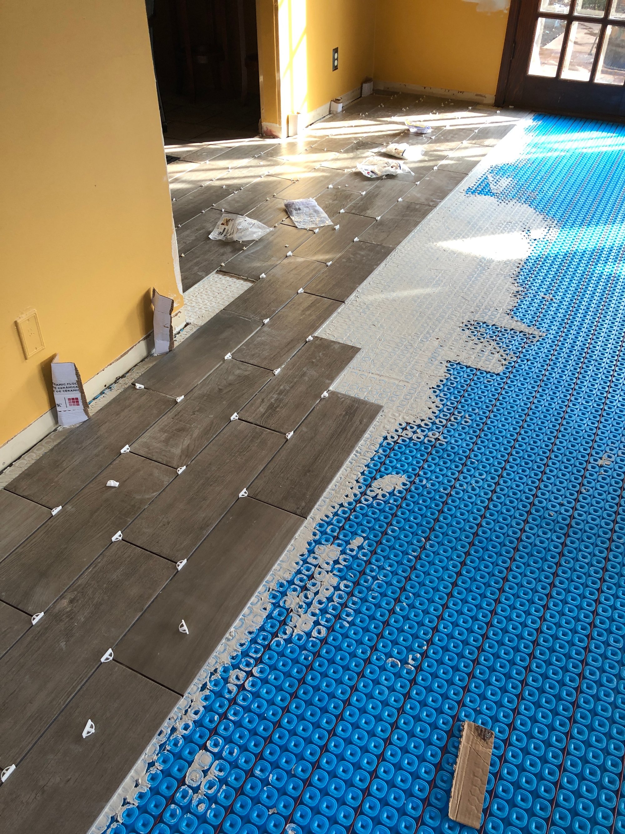 Installing tile over floor heating and uncoupling membrane