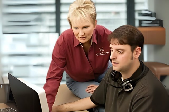 WarmlyYours president Julia Billen collaborating with a customer support technician at an office desk.