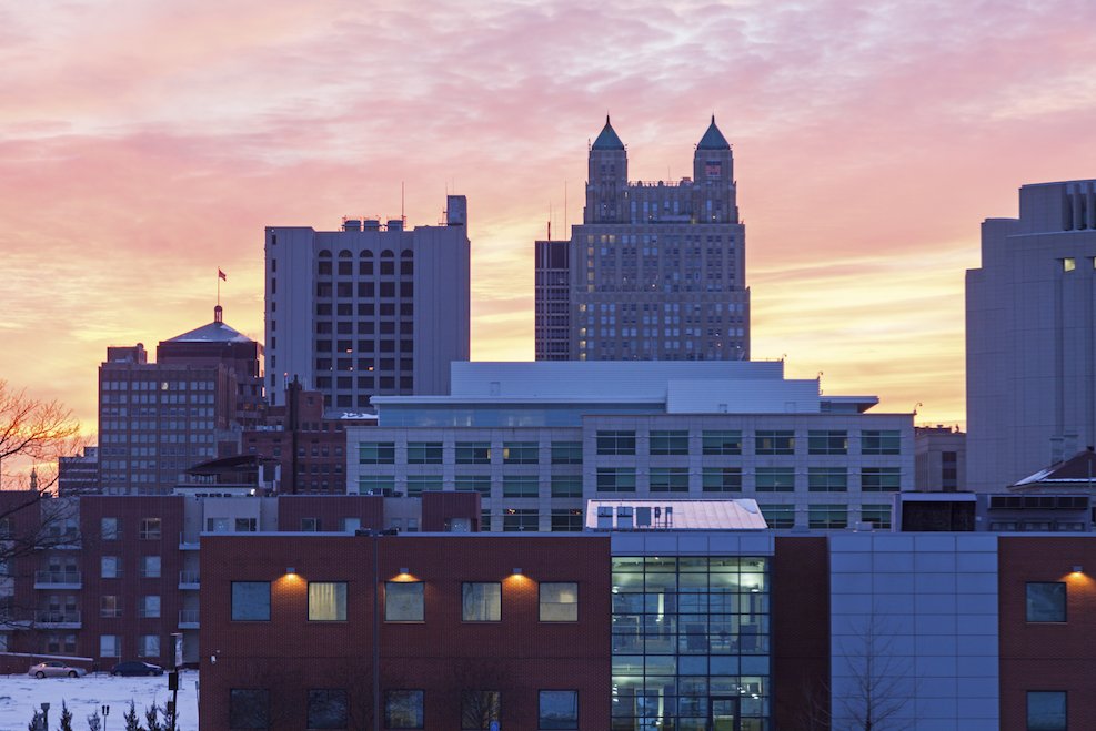 The Kansas City skyline at sunset featuring high-rise office buildings and snow-covered streets.