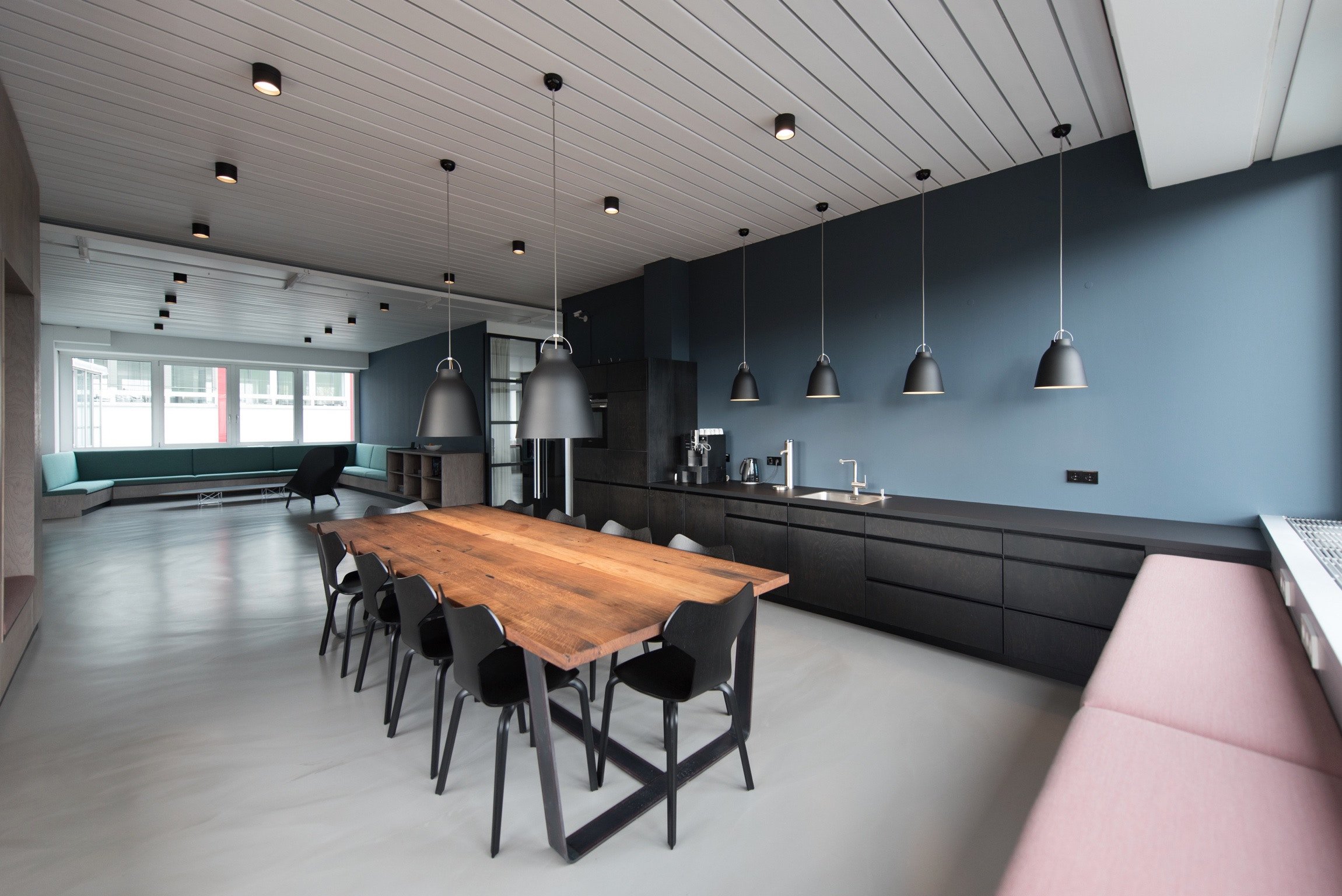 Modern open-plan kitchen and dining area featuring a seamless light grey floor suitable for electric radiant floor heating.