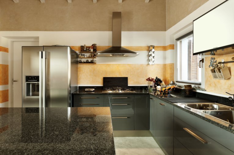 A remodeled kitchen featuring dark grey cabinetry, granite countertops, and stainless steel appliances in an open-concept layout.