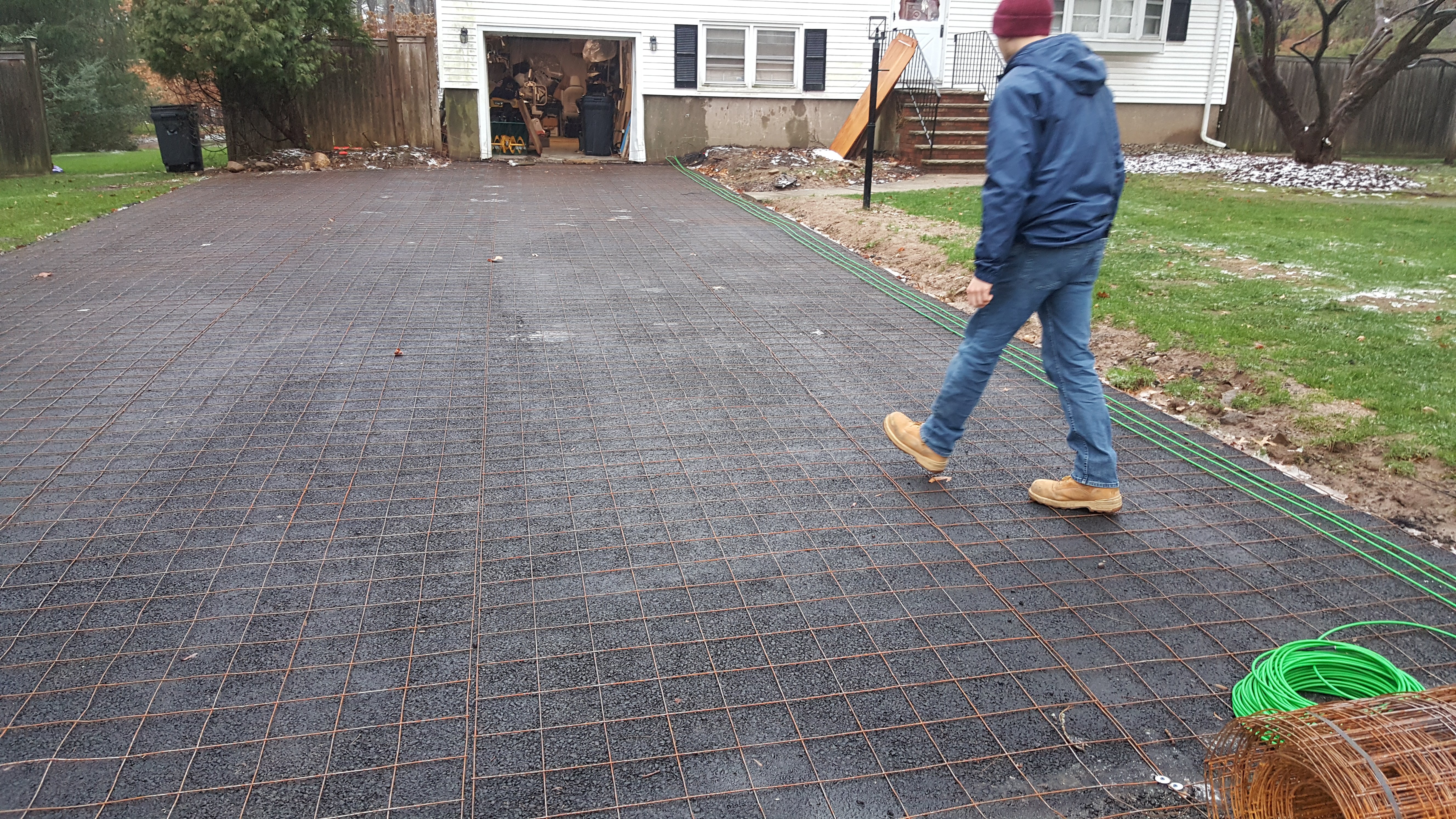 Snow melting heating cable and wire mesh installed on an asphalt driveway in preparation for a residential snow melting system.