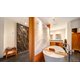 Freestanding bathtub next to a custom stone wall featuring electric radiant underfloor heating.