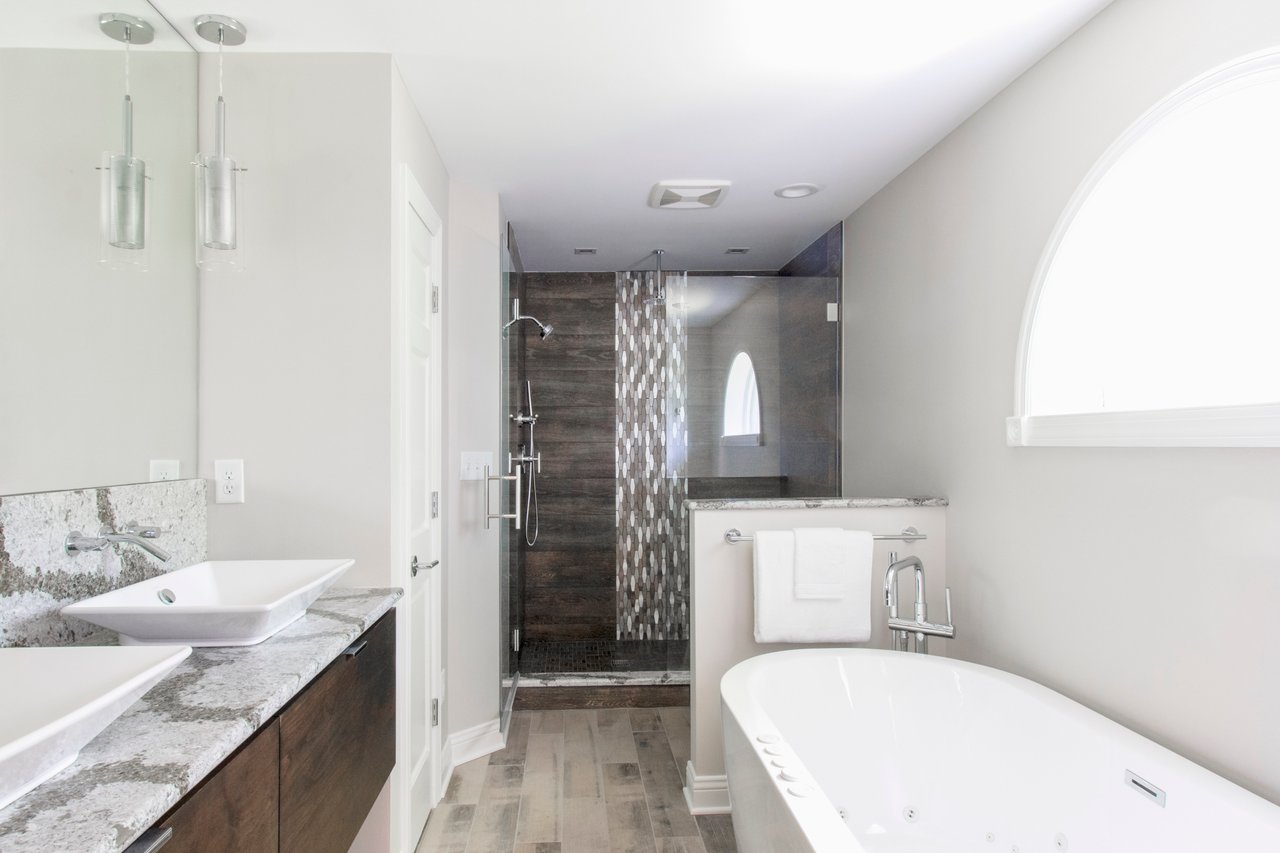 Modern master bathroom in Pewaukee, WI featuring radiant floor heating beneath wood-look floor tiles.