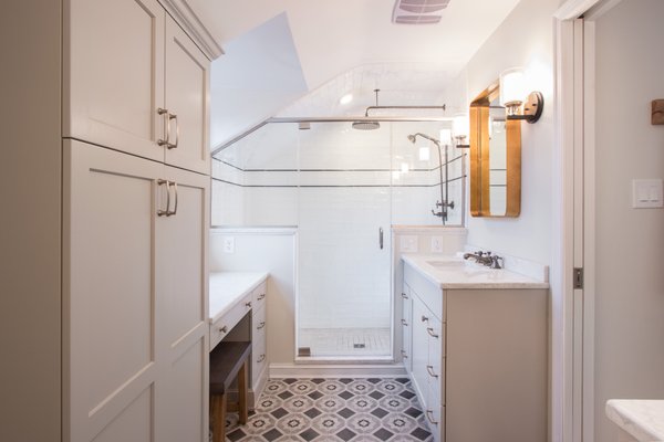 Long bathroom view showcasing heated stone tiles leading to a modern walk-in shower