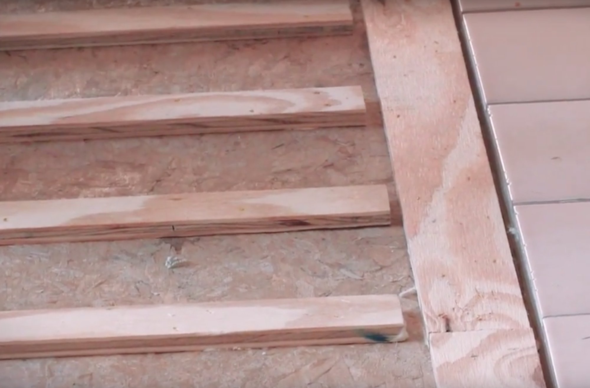 Nailed hardwood floor installation closeup of sleepers attached to subfloor