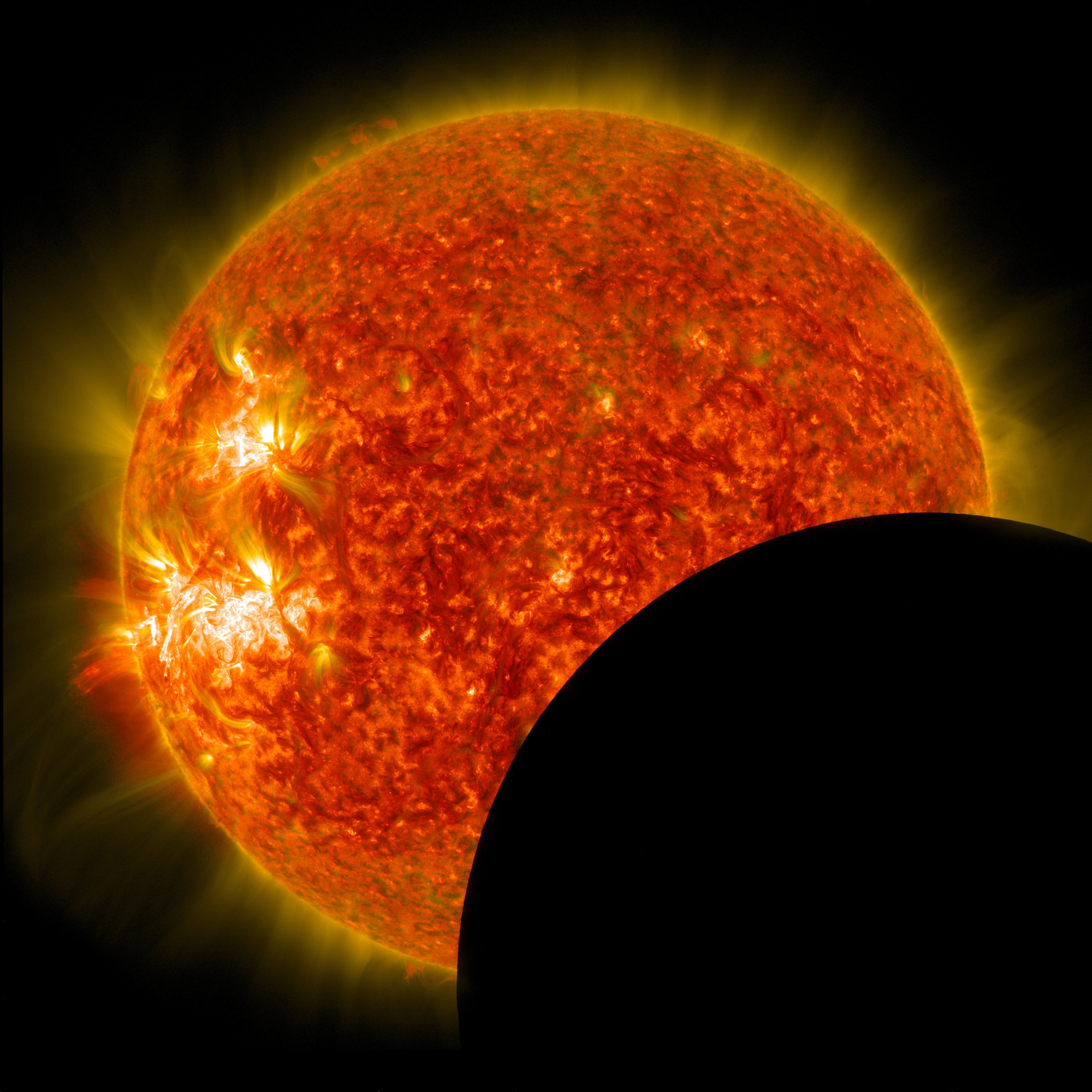 A NASA solar eclipse photo showing the sun as a textured orange sphere with solar flares partially eclipsed by the dark silhouette of the moon.