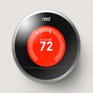 A Nest Learning Thermostat mounted on a wall displaying a heating status and a target temperature of 72 degrees for radiant floor heating.