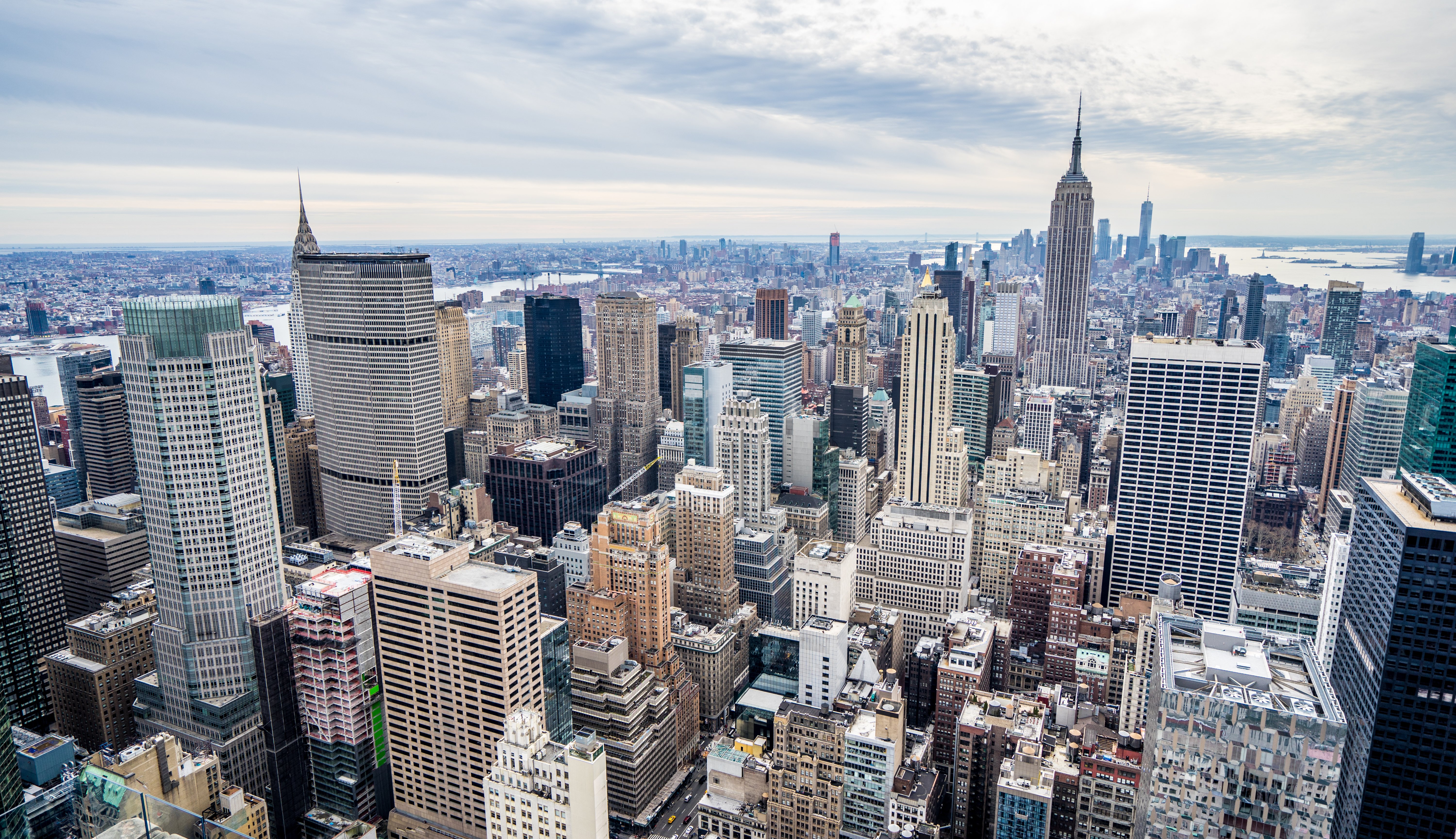 Snow-covered skyscrapers and urban cityscape of Midtown Manhattan under an overcast winter sky.