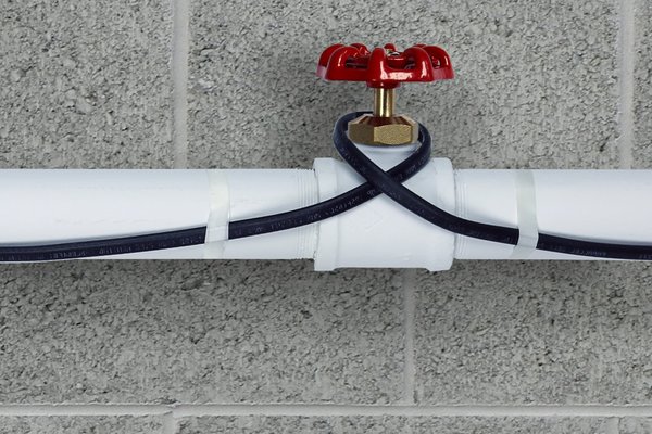 Pipe freeze protection heating cable installed on plastic pipe close