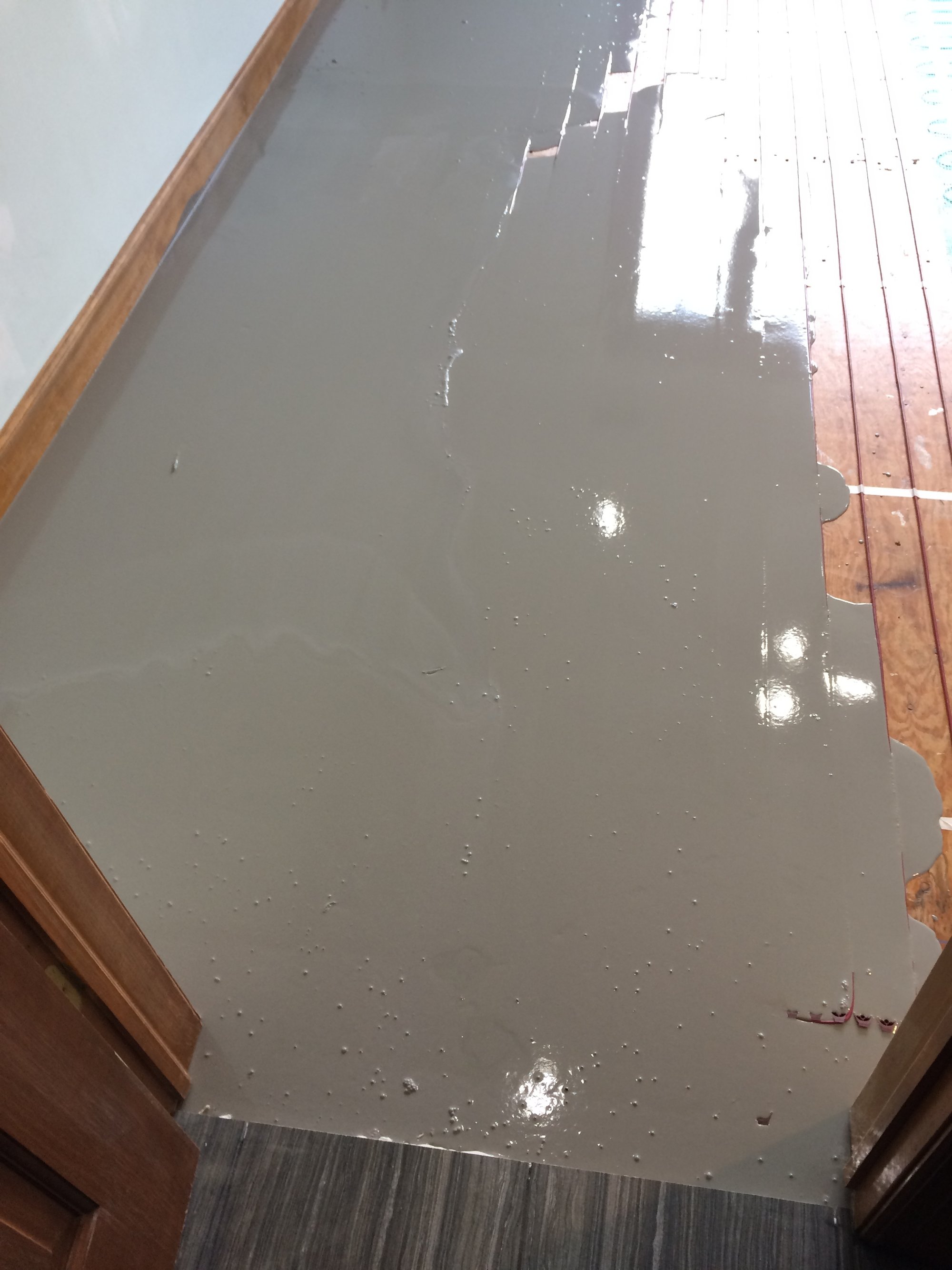Pouring self leveling cement over floor heating system