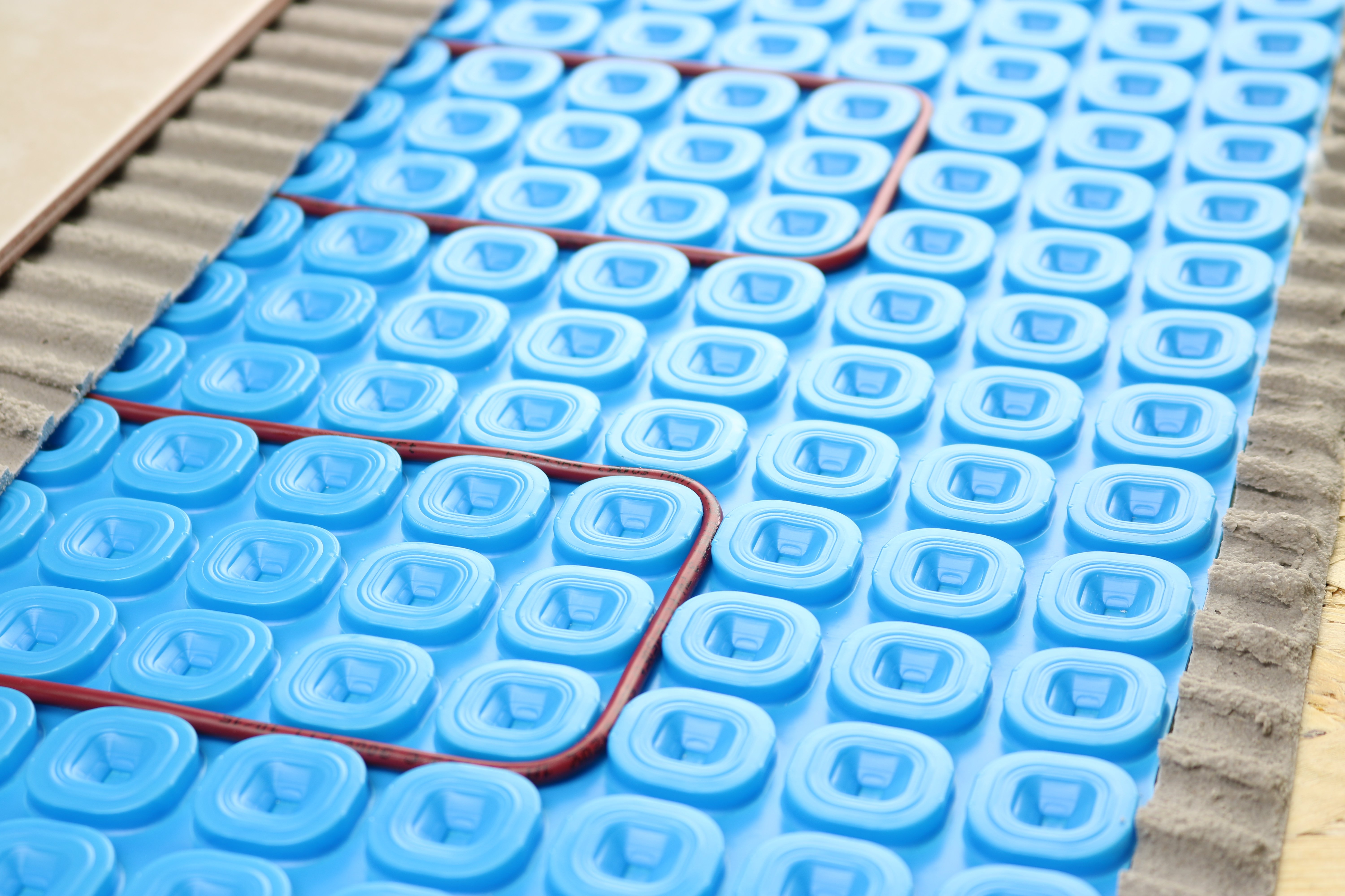 Uncoupling membrane with floor heating cable, thinset, tile, and subfloor